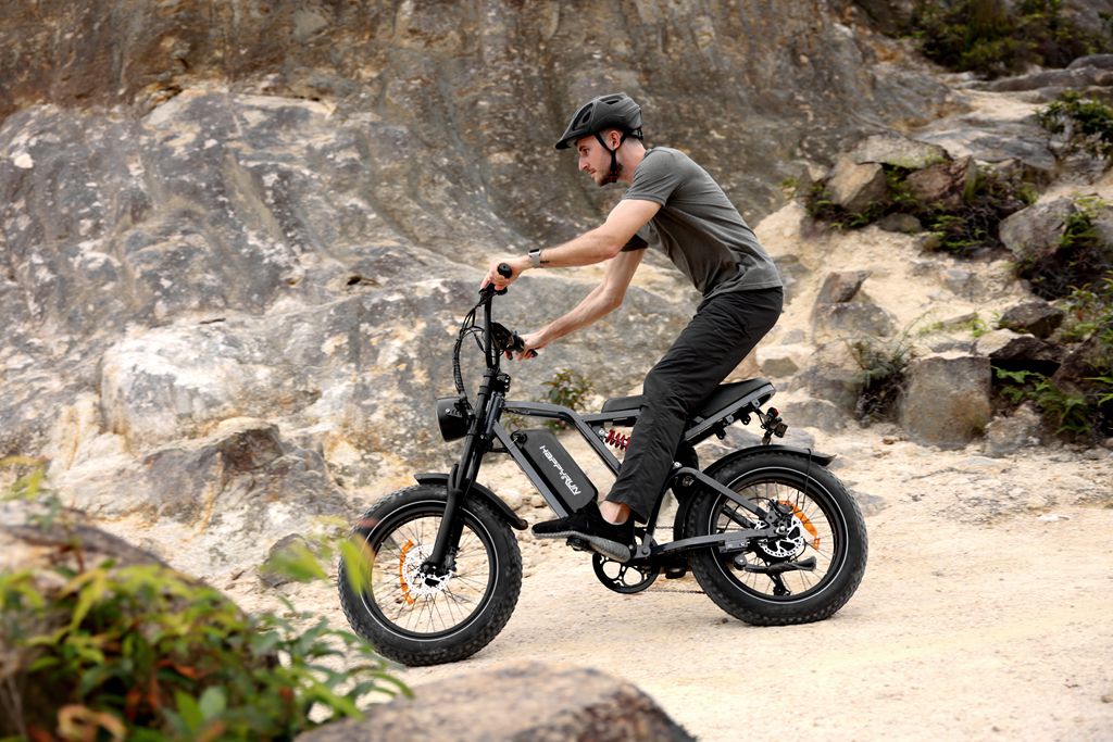 A man is pedaling a HappyRun Tank G60 Pro moped-sytle offroad 1000W electric bike